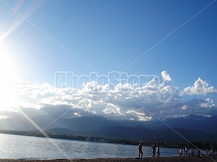 sun clouds mountains and beach