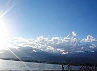 sun clouds mountains and beach